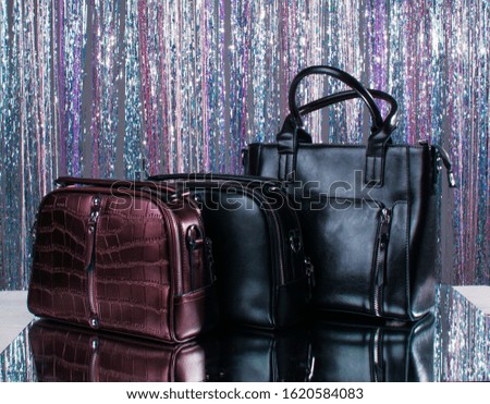 Three leather bags of different colors on a beautiful studio background