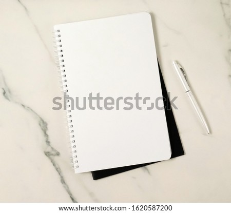 Notebook mock up and pen top view on marble background. Copy space