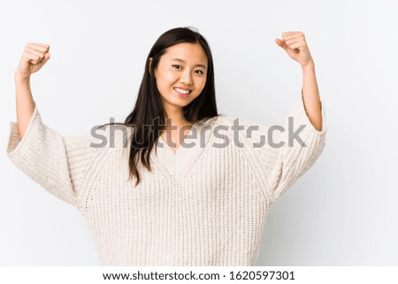 Young chinese woman isolated showing strength gesture with arms, symbol of feminine power