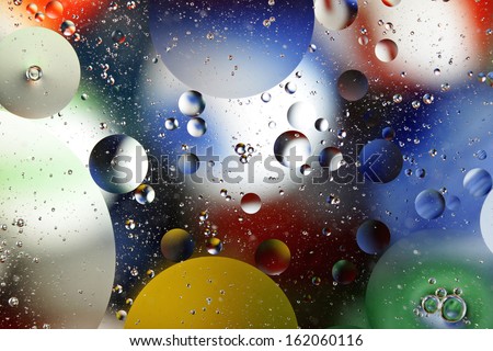 Oil floating on water over bright colors.