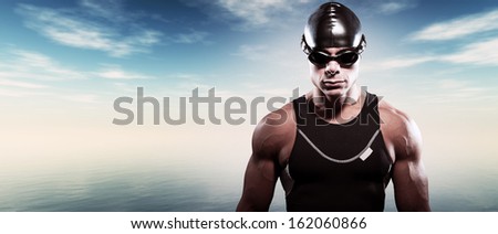 Swimmer triathlon muscled man with cap and glasses outdoor at a lake with blue cloudy sky. Extreme fitness sport. Royalty-Free Stock Photo #162060866