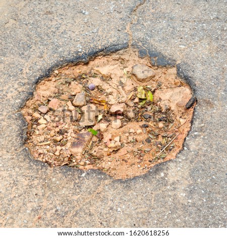 A large pothole in the middle of road in South Africa. Maintenance concept image. 