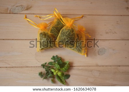 growing and drying organic fresh herbs and spices in reusable organza bags in the balcony at home, herbs placed on wooden table (basil, thyme, oregano), healthy lifestyle with unsprayed food Royalty-Free Stock Photo #1620634078