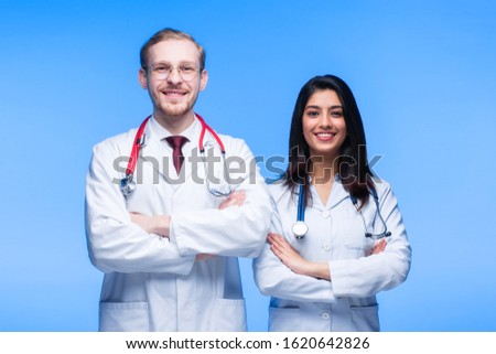 A team of young doctors. Multinational people - doctor, nurse and surgeon in blue background. A group of medical students of different nationalities are looking in the cell.