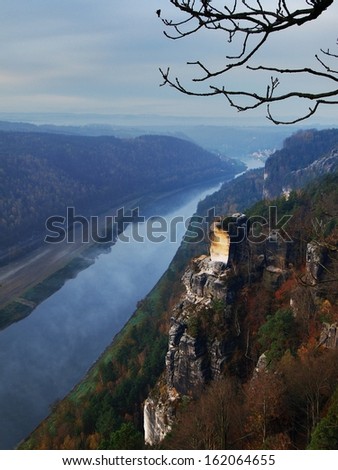Early morning above the river at beautiful park  Saxony Switzerland. Peaks of hills increased from foggy background, the mist is increasing from river. 