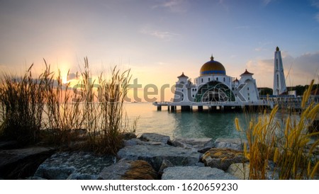 Sunsets, clouds and waves at Straits Mosque of Malacca. Soft focus is duee to long exposure photography.