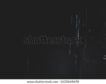 Dust and scratches on black surface. Abstract background. Texture scratched layer. Old grunge background filter effect.