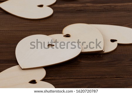 wooden hearts placed nicely on a wooden backgroud.