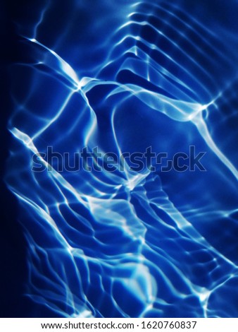 The abstracts of metal texture on surface water. Pattern​ of reflection​ on deep sea water for background. Blue water​ texture​ for​ 3d background.