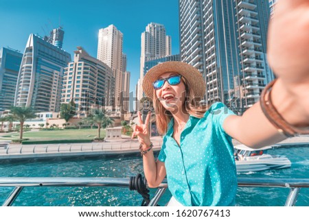 Happy girl traveler taking selfie photo for her social networks in modern Finance center and bay area. Student and Tourist Blogger lifestyle concept