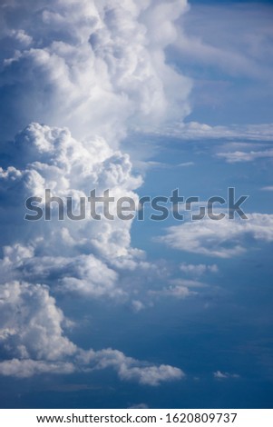 Aerial view with fluffy cumulus clouds on a background of blue sky, copy space. Travel and tourism concept.