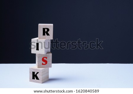 Risk management concept. Four wood cubes R, I, S in red, and K staked creatively to represent the concept. 
