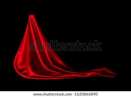 Satin red fabric on a black background. Abstract design.