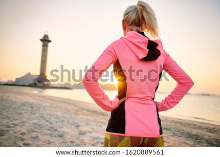 Rear view of sporty woman on the beach 