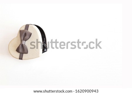 gift box in the form of a heart with a gray bow on a white background. place for your text