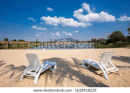 Two white chair on the beach and cloud and blue sky.