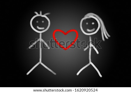 Red heart between happy couple drawing with chalk on black background, couple and love concept.