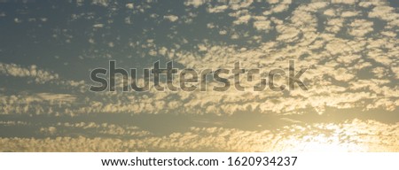 Cirrus cumulus clouds at sunset. Banner.