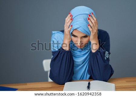 Unhappy muslim female student learning at home