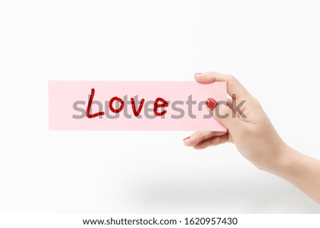 Close up women holding pink paper with LOVE text on white background.