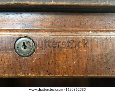 An old desk lock on a wooden drawer Royalty-Free Stock Photo #1620962383