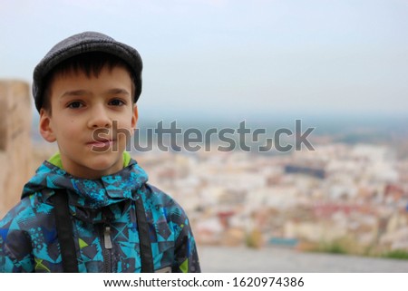 portrait of a young boy with the photo camera and the spanish old town on the background