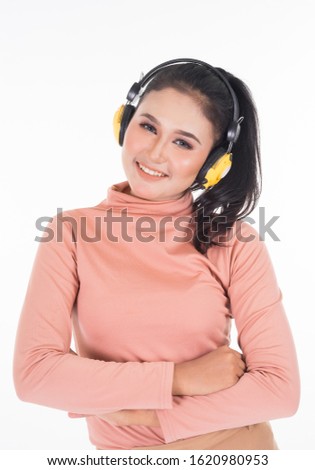 Cheerful Asian teenager wearing turtleneck and pants using wireless headphones enjoying listening to music studio portrait shot isolated on white background. Easy to cut out. Portrait orientation.