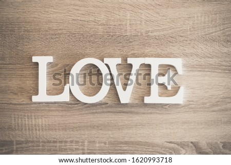 Letters form the word love on wood with rustic background, vintage wallpaper.