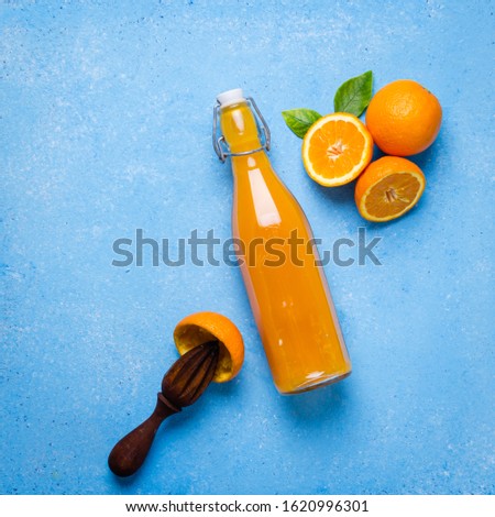 Orange juice in glass with fruits on turquese  background, copy space.