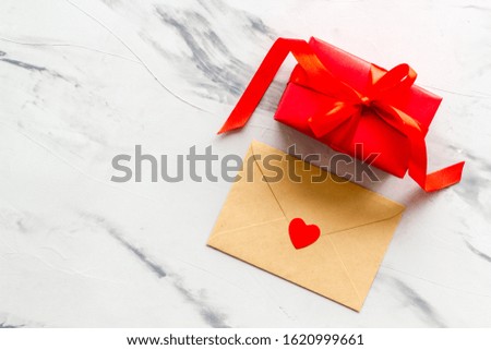 Valentine's Day. Love letter and red box. White marble background top view mockup