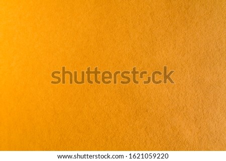 Ochre colored paper sheet background or texture 