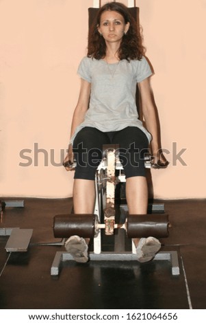 Workout fitness exercises in the gym. Power simulator for legs. Gymnastics.