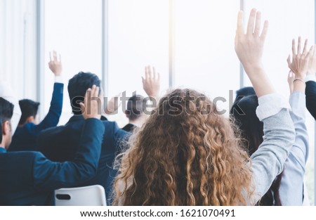Audience raising hands up while businesswoman is speaking in training at the office. Seminar concept. Business model.