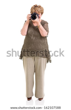 elderly woman shooting pictures with digital SLR camera on white