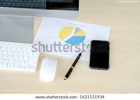 Office desk with monitors keyboards Mobile and the different graphs on paper.