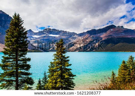 The Majestic Rockies of Canada. The picturesque deep Lake Bow is surrounded by cliffs and glaciers. Windy Autumn Day. Lake cold glacial water is rippled. The concept of active and photo tourism