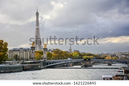 Autumn colourful view of the river Seine in Paris, France, with the Pont Alexandre III and Eiffel Tower in the background with the dramatic blue sky