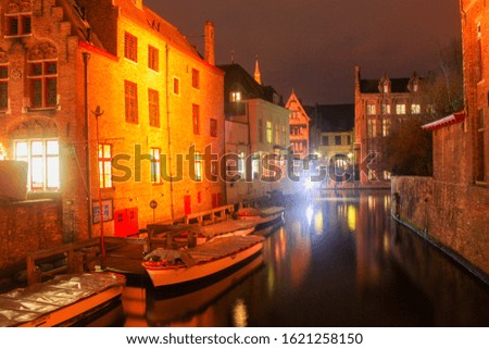 Picturesque night view of the  old street holiday exterior of Brugge , Belgium in winter on Christmas time. Lights, street, houses are reflecting in dark still water