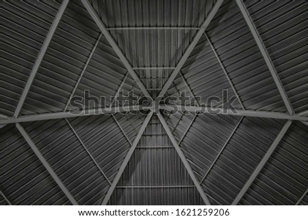 Round and symmetrical pergola dome, roof of a catholic church on Saloum island in Senegal, Africa. It is a gray tin background. It's a bottom view.