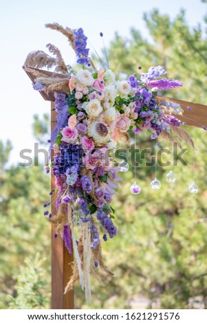 Decorative decoration of the wedding arch with fresh flowers. Holding a wedding ceremony in the open. Decoration details.