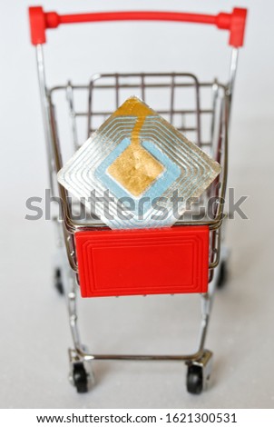 The metal trolley from the supermarket, in which lies the RFID tag. Goods security and alarm. Vertical picture. Close-up. Picture for warning shoplifters.
