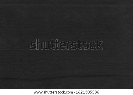 Cardboard black abstract texture close-up. Dark old paper background. Grunge concrete wall. Vintage blank wallpaper.