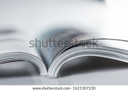 Pile of Open magazines, blue toned image Royalty-Free Stock Photo #1621307230