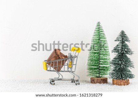 shopping trolley filled with small gifts on white background. christmas concept. new year composition