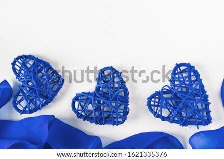 Three blue hearts and a frame from silk fabric on a white background. Place for text