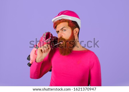 Bearded man with roller-skates. Man with roller skates and helmet. Active sport. Roller skating ride. Healthy lifestyle. Holidays. Vacation. Protective sport helmet. Protective sport equipment.