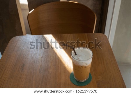 Glass of milk coffee drink on wooden table, stock photo