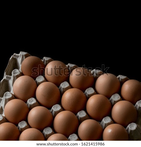 Fresh eggs on black background, view from the top 