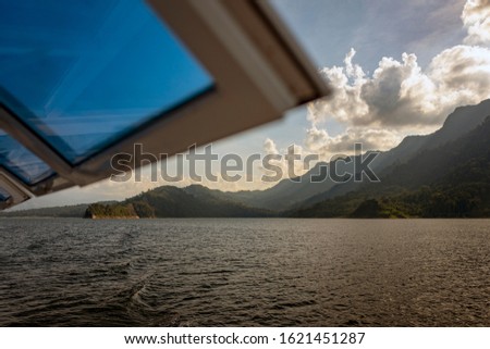 Stunning panoramic landscape view of the Sogamoso river reservoir dam near the city of Bucaramanga and Zapatoca town seen from a moving boat with a row of polarized windows open and closed