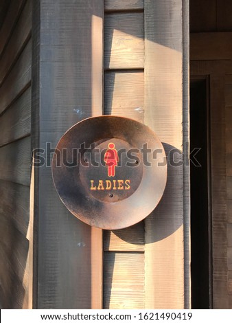 Woman rest room sign on wooden wall